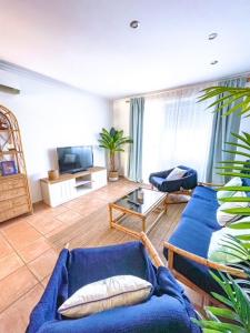 a living room with a blue couch and a table at Apartamento Primera Línea Marines Racons, Les Deveses, Denia in Casas Devesa
