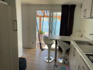 a kitchen with a table and chairs and a window at Bungalow Lido Eve in Colico