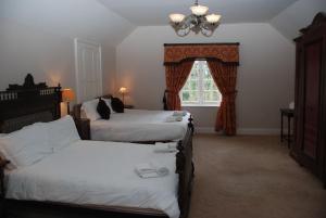 a hotel room with two beds and a window at Woodbank in Caerleon