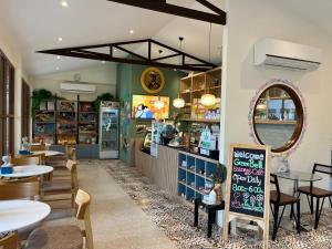 a restaurant with tables and chairs and a mirror at Bann Tulip Khaoyai in Mu Si