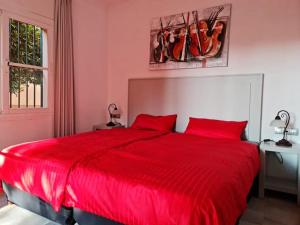 a red bed with red pillows in a pink bedroom at Oasis Golf Apartment in Sitio de Calahonda +31 photos