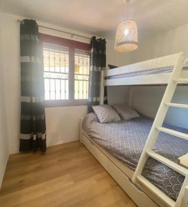 a bedroom with a bunk bed and a window at Appart 70m2 avec piscine in Saint-Geniès-de-Varensal