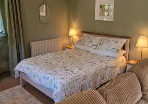 a bedroom with a bed and a couch at The Old Barn at Bosillion House in Grampound