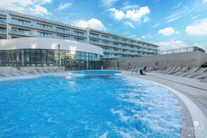 ein großes Schwimmbad vor einem Gebäude in der Unterkunft Polanki Aqua Exclusive - by Jantar Apartamenty Kołobrzeg in Kołobrzeg + 83 Fotos