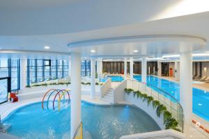 einem großen Innenpool mit Rutsche in einem Gebäude in der Unterkunft Polanki Aqua Exclusive - by Jantar Apartamenty Kołobrzeg in Kołobrzeg