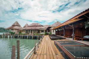 a house on the water with a dock at Salakphet Resort in Ko Chang