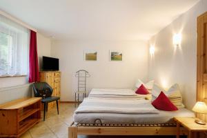 a bedroom with a large bed with red pillows at Ferienhaus Sonnenhof in Blankenburg