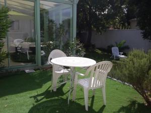 VelleronにあるNice flat with jacuzzi and gardenの白いテーブルと椅子2脚