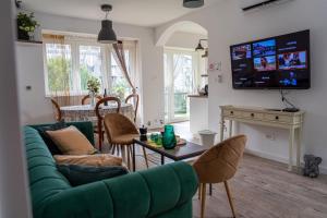 a living room with a green couch and a table at apartman Frida in Zagreb