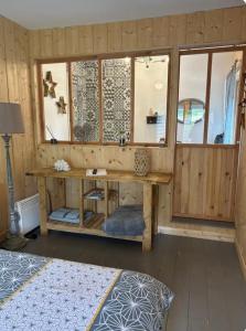 una stanza con una parete di legno con una scrivania e finestre di Le chalet du bonheur a Gujan-Mestras