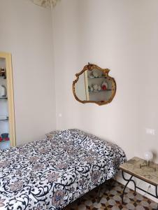 Un dormitorio con una cama y un espejo en la pared. en La dimora del MARCHESE NOTARBARTOLO, en Palermo