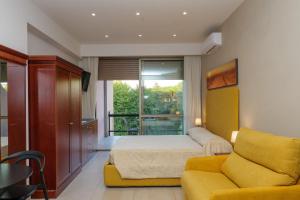 a bedroom with a bed and a yellow couch at Domus Aurelia in Rome