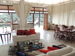 a living room with a couch and a table at Pousada R.N.C. Nosso Paraíso in Teresópolis