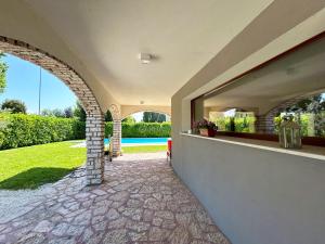 eine Außenansicht eines Hauses mit Torbogen in der Unterkunft Villa Marina - Risveglio Vista Lago con Piscina in San Martino della Battaglia