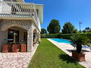 ein Haus mit einem Garten mit einem Swimmingpool in der Unterkunft Villa Marina - Risveglio Vista Lago con Piscina in San Martino della Battaglia