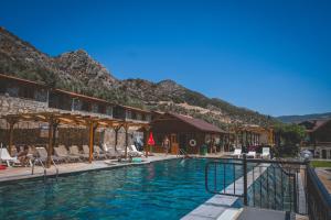 a pool at a resort with mountains in the background at Natureland Efes Pension in Selçuk
