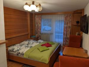 a small bedroom with a bed and a chair at Montahaus Retro Apartments in Vandans