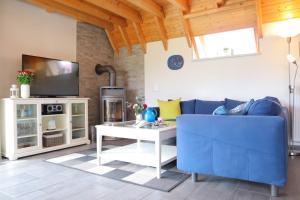 a living room with a blue couch and a tv at Ferienhaus Zimmers-Nordseehaus in Dorum Neufeld