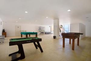 a room with two ping pong tables and a pool table at Praia Areia Branca in Lourinhã