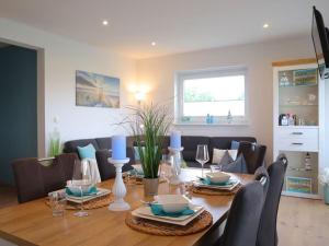 a dining room with a wooden table and chairs at Ferienhaus Luv in Dorum Neufeld