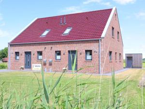 a large red brick building with a red roof at Ferienhaus Luv in Dorum Neufeld