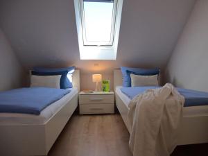 two beds in a small room with a window at Ferienhaus Lee in Dorum Neufeld