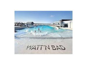 a swimming pool with people in the water at Ferienhaus Poseidon in Dorum Neufeld