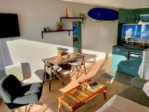 a living room with a table and a dining room at Biarritz centre avec accès plage in Biarritz