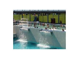 a swimming pool with people in the water at „Achtkanthus Achtern Diek“ in Dorum Neufeld