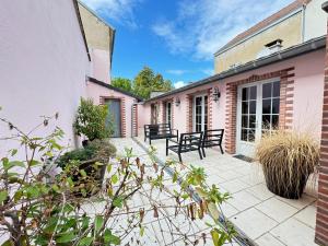 une cour d'une maison avec deux bancs dans l'établissement Maison Évasion Vichy14 couchages, à Vichy