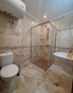 a bathroom with a shower and a toilet and a sink at Уютно студио до морето - апартаменти 25 и 26, топ локация - Cozy Studio by the Sea - Apartments 25 and 26 Top Location in Sveti Vlas