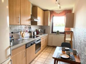 a kitchen with wooden cabinets and a small table with a table at Ferienwohnung Laura in Bad Sachsa
