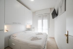 ein weißes Schlafzimmer mit einem Bett und einem Fernseher in der Unterkunft Formigine - [Motor Valley-Homes] in Formigine