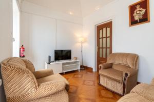 a living room with two chairs and a television at Casa Da Tia in Arco da Calheta