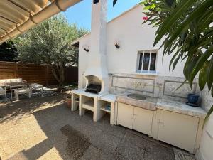 una cocina al aire libre con parrilla en el patio trasero en Villa Centre Mandelieu-la-Napoule, en Mandelieu-la-Napoule 4 fotos más