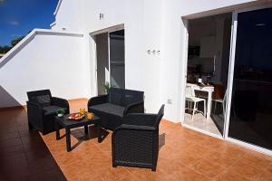 ein Wohnzimmer mit schwarzen Stühlen und einem Tisch in der Unterkunft Apartamento,BBQ, cerca del mar in Charco del Pino