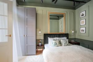 un dormitorio con una cama y un espejo en TurnKey I Antonin Dvorak Apartments, en Praga