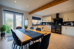 een keuken met een houten tafel en stoelen in een kamer bij Lime House By Horizon Stays in Redcar