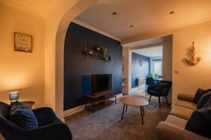 een woonkamer met twee banken en een tv bij Lime House By Horizon Stays in Redcar