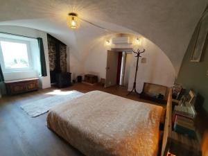 a bedroom with a large bed and a window at La Maison Arcolan in Corps