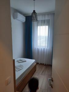 a small bedroom with a bed and a window at Eagles Locus Apartments in Ulcinj