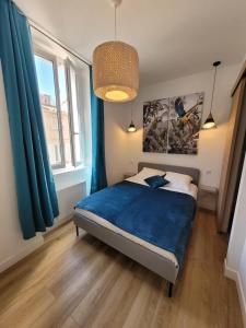 una camera da letto con letto con lenzuola blu e tende blu di 06AN - Beautiful apartment in the heart of Old Antibes a Antibes Altre 14 foto