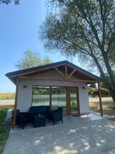 a pavilion with a table and chairs on a patio at Bene- hegyi apartmanok in Csepreg +20 photos