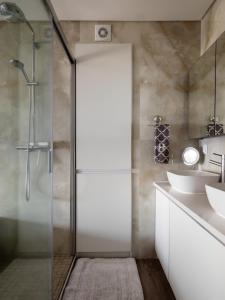 a bathroom with a glass shower and a sink at Azzurro at Sea in São Roque +10 photos
