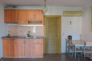 a kitchen with wooden cabinets and a table and a dining room at Natureland Efes Pension in Selçuk