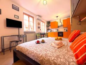 ein Schlafzimmer mit einem Bett und eine Küche mit orangefarbenen Schränken in der Unterkunft ZenHouse - Nel cuore del centro storico di Torino in Turin