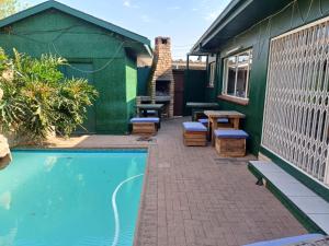 a backyard with a swimming pool and a green building at Platinum Loft in Klerksdorp