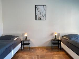 two beds in a room with two lamps on tables at Geräumige Monteurwohnung in Ibbenbüren