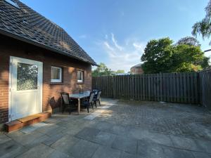 a patio with a table and chairs and a fence at Geräumige Monteurwohnung in Ibbenbüren