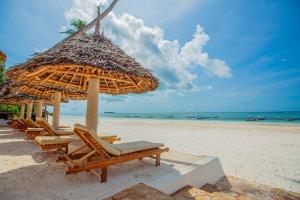 a group of chairs and umbrellas on a beach at AHG Dream's Bay Beach Hotel - Adults Only in Matemwe